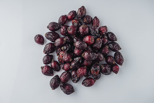 dried red rose hips on a white background