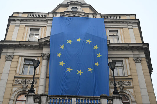 Large European Union flag displayed on a building facade in Sarajevo, Bosnia and Herzegovina. Prominent EU banner hanging from office building.