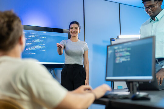 Asian female developer presents code review insights and feedback to team, demonstrating technical leadership and collaborative code discussion with colleagues.