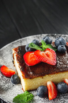 delicious freshly baked Basque cheesecake on a black wooden rustic background