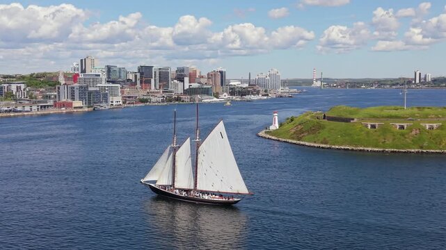 The majestic Bluenose glides effortlessly across the shimmering waters of Halifax Bay, framed by a brilliant, azure sky above