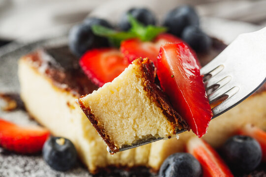 delicious freshly baked Basque cheesecake on a black wooden rustic background