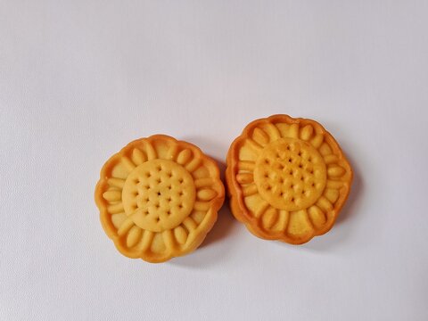Top view of two flower shaped baked cookies or mooncakes on a white isolated background