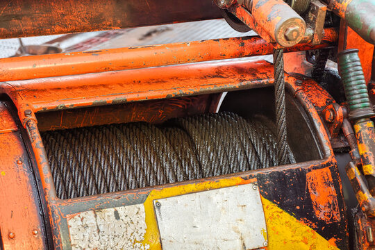 An air winch machine on the drilling rig floor, assembly with iron wirerope sling, the equipment using for lifting heavy equipment in the drilling operation. Industrial equipment object, close-up.