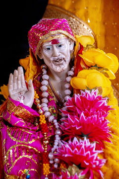 Statue of Sai Baba adorned with flower garlands and necklaces in a temple in Palampur, Himachal Pradesh, India