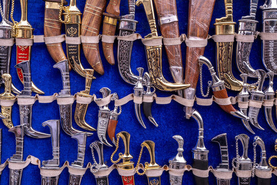 A collection of traditional daggers and knives adorned with Sikh symbols, sold in Amritsar, India