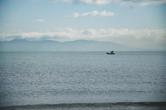 Minimalist landscape of a small fishing boat on a calm sea