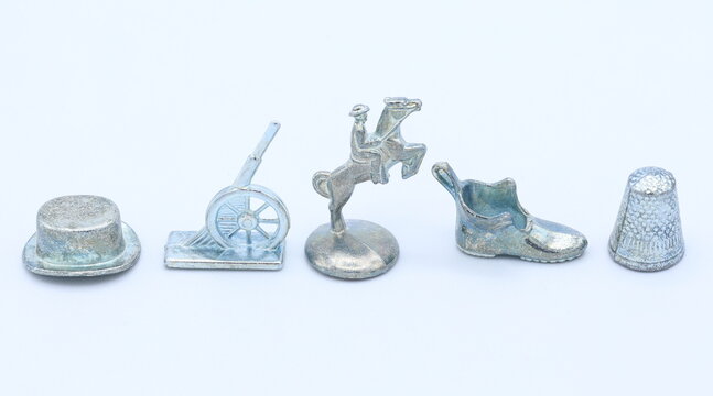 Monopoly metal game pieces. Hat, cannon, horse, shoe and thimble. Close up and isolated.