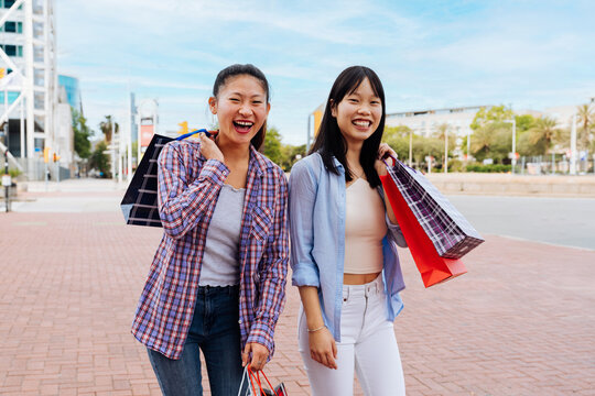 Happy beautiful chinese women friends bonding in the city