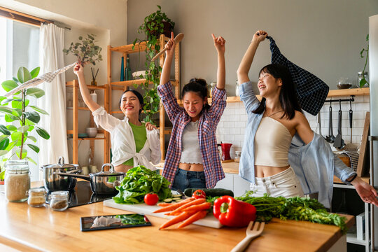 Happy beautiful chinese women friends bonding at home
