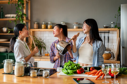 Happy beautiful chinese women friends bonding at home