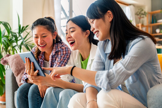 Happy beautiful chinese women friends bonding at home