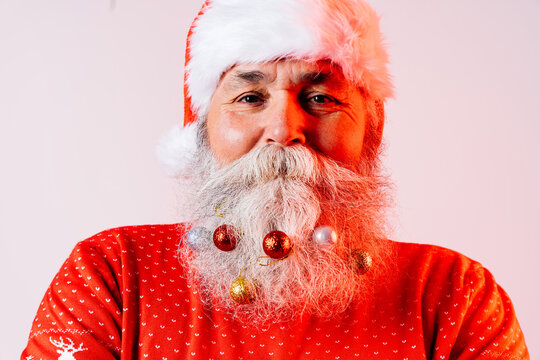 Senior old man with gray beard with Santa Claus hat portrait in studio
