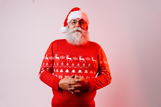 Senior old man with gray beard with Santa Claus portrait in studio