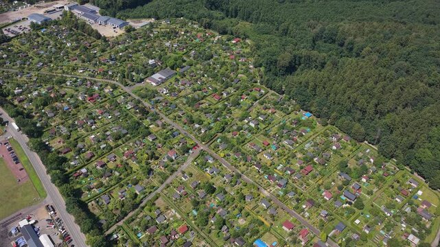 Aerial view of allotment gardens and forest border in a european city