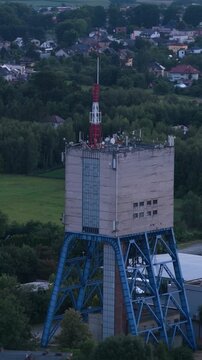Industrial mining headframe tower with communication antennas in a rural landscape