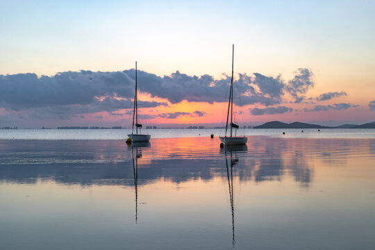 View of the Mar Menor at dawn with two boats on its waters, Punta Prima, Cartagena, Region of Murcia, Spain