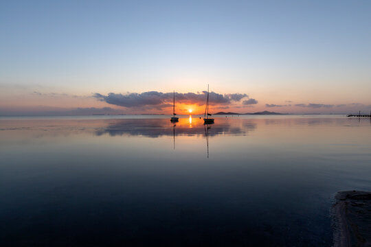 View of the Mar Menor at dawn with two boats on its waters, Punta Prima, Cartagena, Region of Murcia, Spain