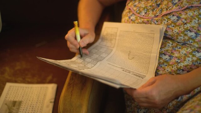 A woman's hands solving a Sudoku puzzle closeup