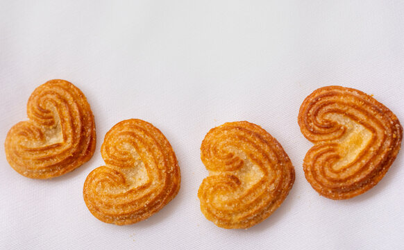 A row of little heart biscuits, sprinkled with sugar granules cookies, love food for Valentine's day concepts. isolated on white background.