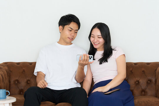 Japanese Man and Woman Using Smartphones Together