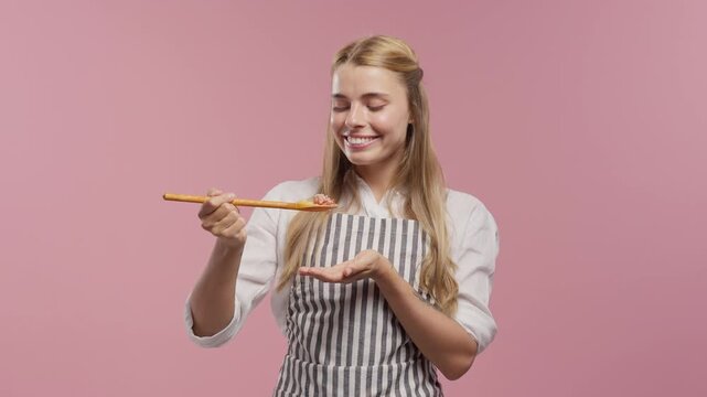 Female Cook Smelling Freshly Prepared Food From Wooden Spoon Before Tasting Her Homemade Dish, Natural Cooking Process, Healthy Cuisine, Sustainable Kitchen And Food Preparation