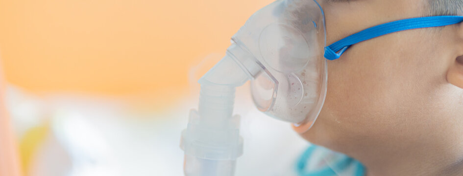 Allergy sufferers Oxygen sick children Sick boy inhalation therapy by the mask of inhaler. Worried sick kid with oxygen mask sitting on bed at hospital ward - concept of breathing problems