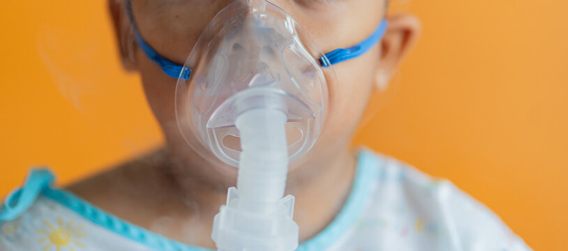 Allergy sufferers Oxygen sick children Sick boy inhalation therapy by the mask of inhaler. Worried sick kid with oxygen mask sitting on bed at hospital ward - concept of breathing problems