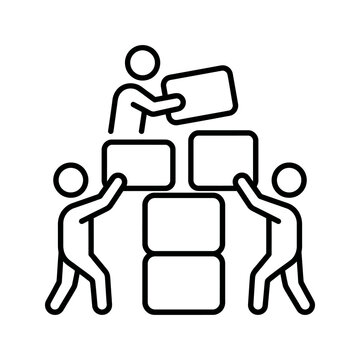 Three people stacking cardboard blocks in a collaborative construction task.