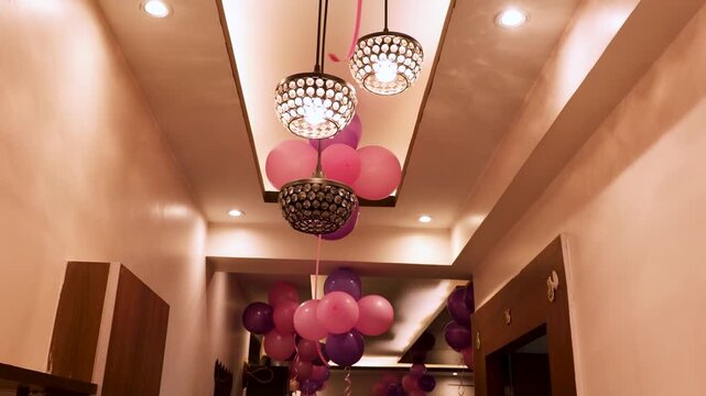 Pink and purple balloons decorating a modern hallway ceiling
