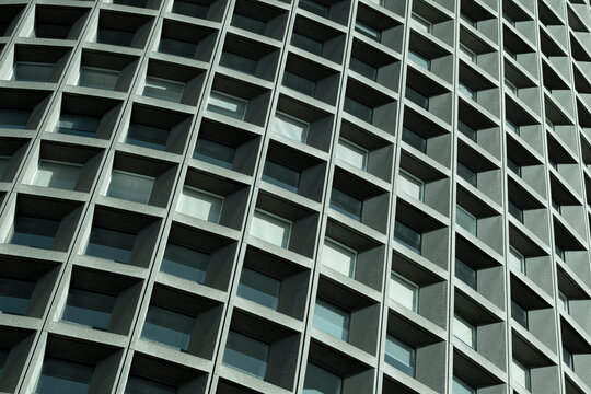 Curved windows recede through a grid in a close study of architecture, while the urban facade builds a dense pattern through repetition and geometry across the building.