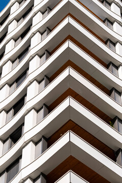 Stacked balconies rise in vertical rhythm through a study of architecture, as the urban tower facade turns repetition into pattern across the building, reinforcing geometry.