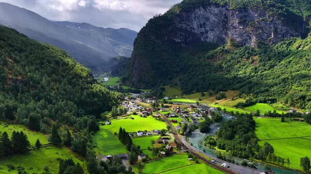 Drone flying above Flam village in Norway, beautiful Norwegian nature in Flam valley, orbiting shot of famous Flam railway along Moldo river, western Norway, travel and tourism in Scandinavia