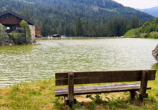  green lake with wooden structure and mountains in the background. peaceful and serene nature scene with vibrant colors and natural beauty. a tranquil setting. Lago di San Vito, Dolomites, Italy