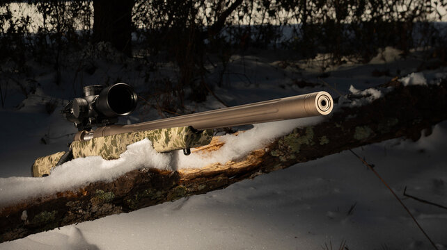 Bolt action rifle in a snowy treeline in winter
