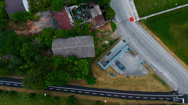  aerial view of urban roundabout with roads and green spaces in neutral setting, showing asphalt, grass, and concrete materials under natural light.