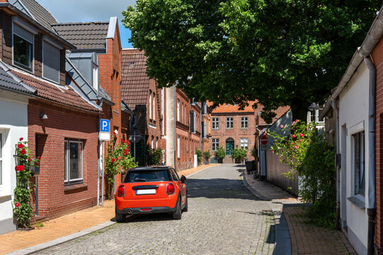 Historic cobblestone street with brick houses in Husum oldtown. Typical northern German residential houses, well-preserved facades and a peaceful lane reflect the historic character of the town.