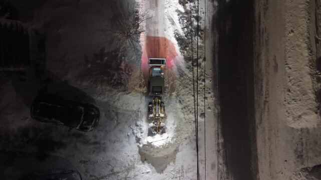 Dramatic night view of snow plow clearing the streets in Beechville after a heavy snowstorm