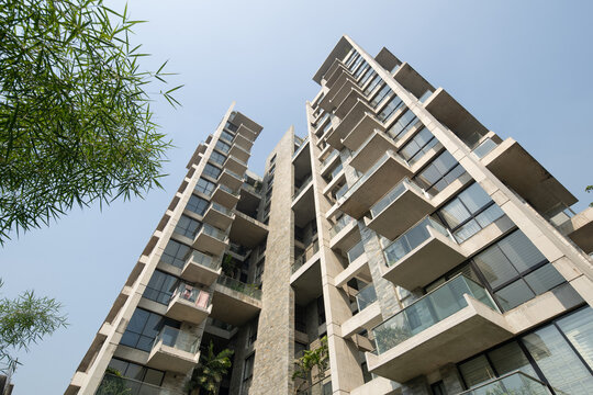Modern High Rise Residential Building with Glass Balconies and Concrete Facade Viewed from a Low Angle