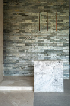 Modern Interior with Textured Stone Brick Wall, Concrete Floor, Marble Counter, and Minimalist Design