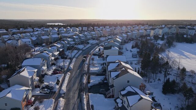 An absolutely breathtaking aerial perspective of beautiful snowy residences in Beachville, Halifax, captured during the enchanting golden hour