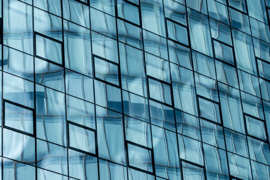 Panel rhythms cross an urban building as repetition spans the facade, then blue reflection shifts across glass before windows organize architecture within layered geometry.