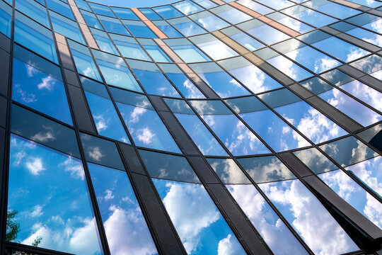 Clouds gather over an urban building as a curved facade opens the view, then sky reflection settles across glass before windows shape architecture into layered geometry.