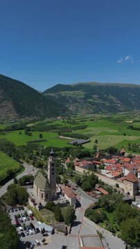 Vertical Drone Orbit Over Glurns Medieval Town and Church in Italy