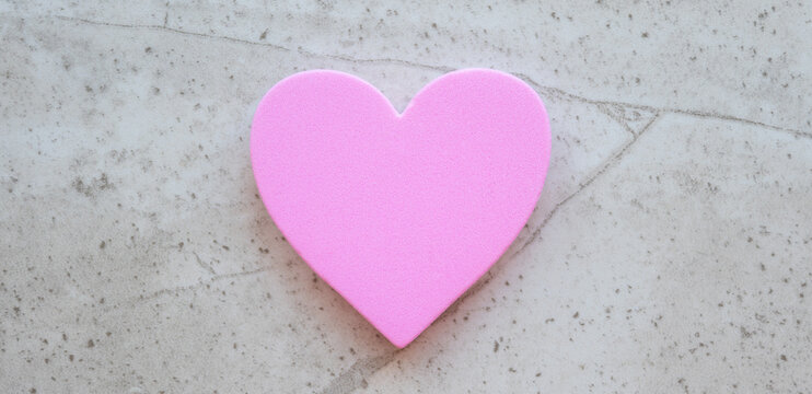 Pink heart on the stone background with space for text.
