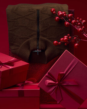 Sweater and gifts arranged in a red setting for the holidays