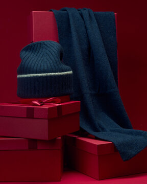 Warm winter accessories on red gift boxes