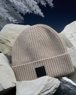 Warm knit hat rests on stones in winter setting