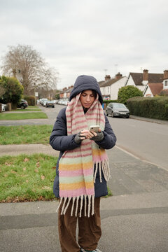 Person Using Phone on Residential Street