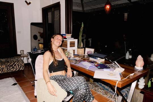 Woman working from home at messy creative desk with flash light